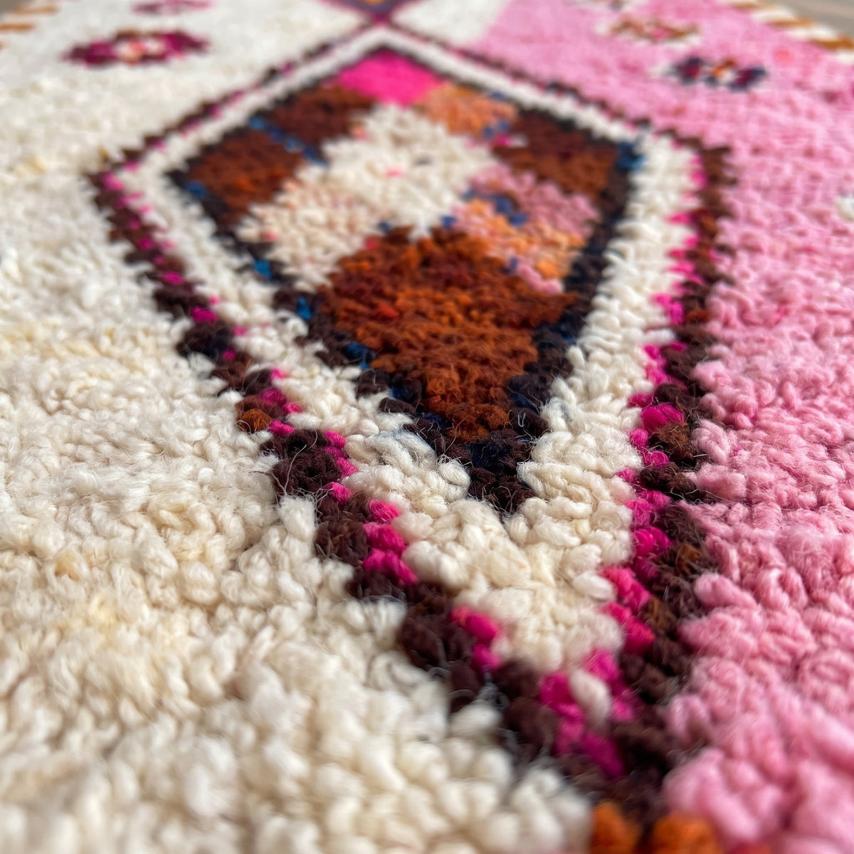 Gros plan sur un motif du tapis d'escalier berbère Mazigh, couloir moitié gauche écrue et moitié droite rose