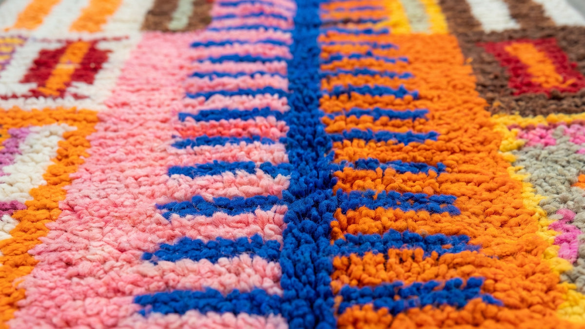 Gros plan sur la laine du tapis d'escalier berbère Amizmiz, poil rose et orange noué à la main