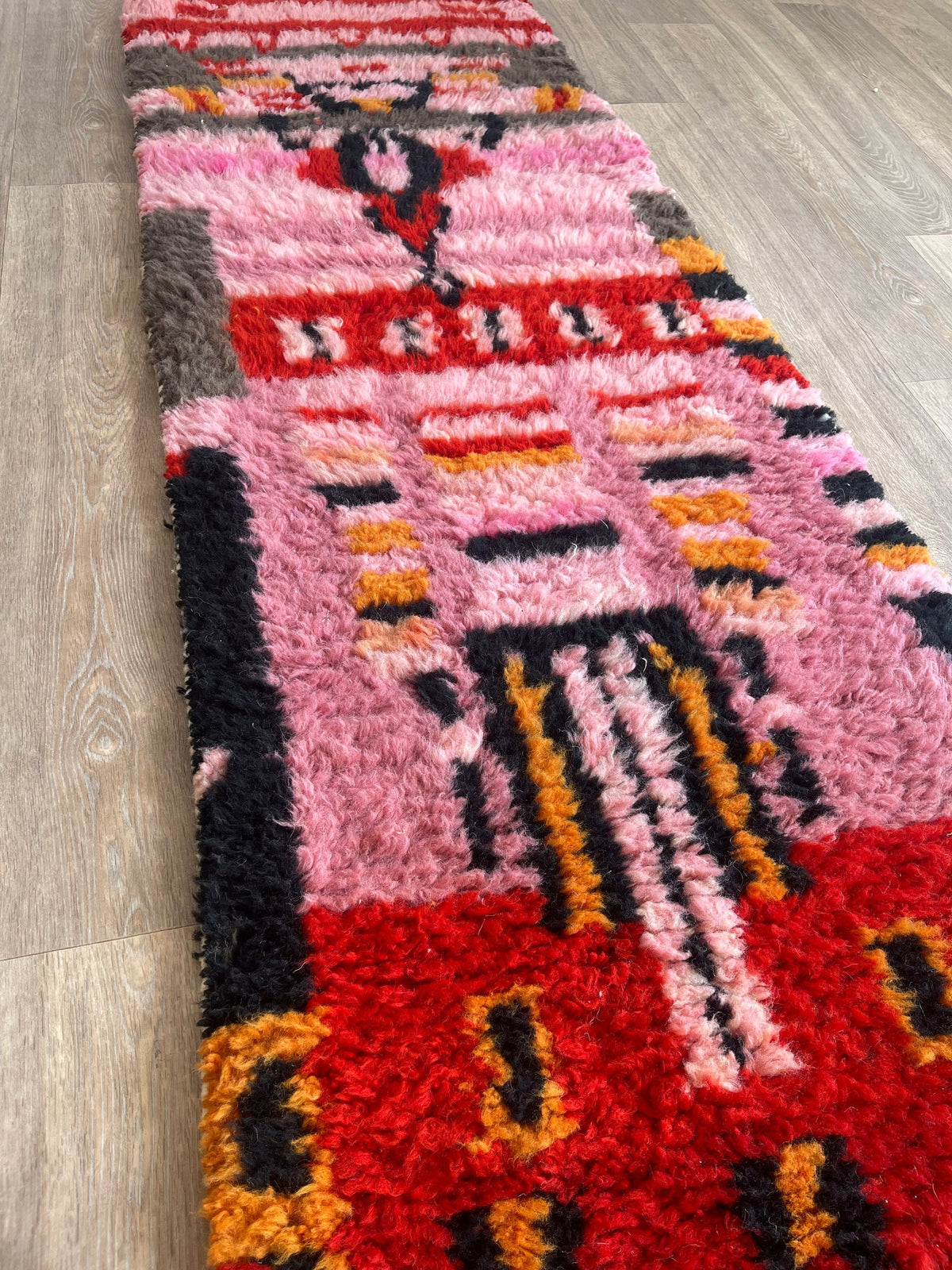 Close-up of a detail on the Imilchil Berber stair runner, long pile and pattern in pink and red seen up close