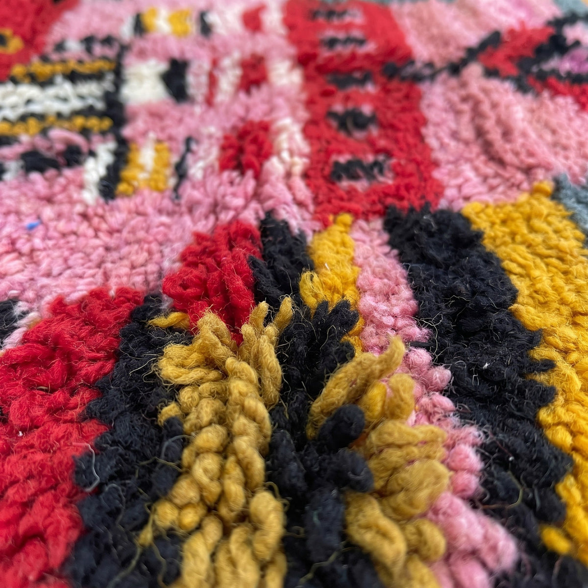 Gros plan sur un motif du tapis d'escalier berbère Rassira, couloir à poil long, bout rouge