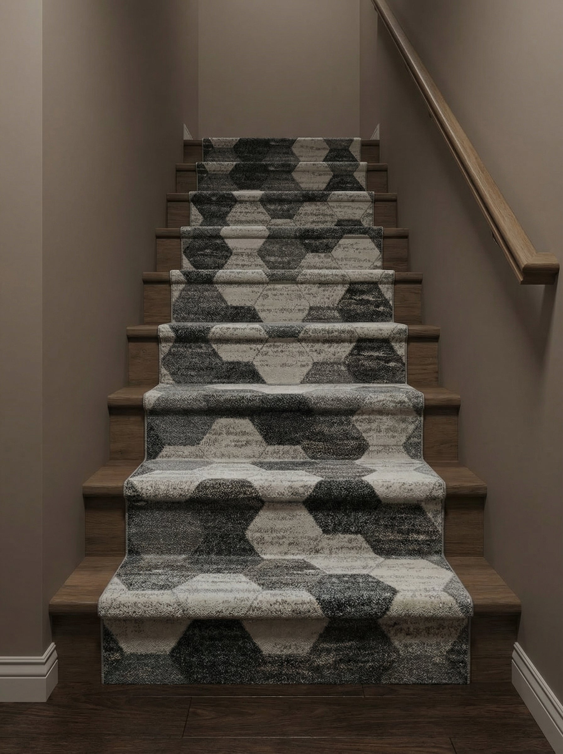Tapis d'escalier texturé aux motifs hexagonaux alternant gris clair et anthracite, recouvrant des marches en bois dans un couloir