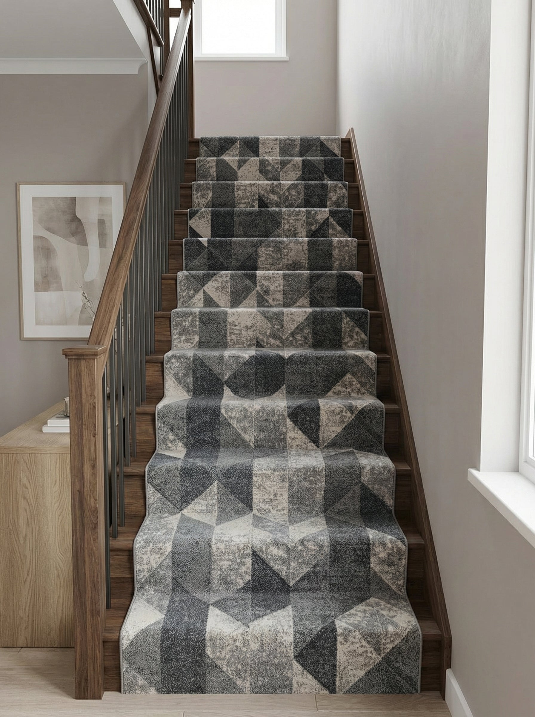 Tapis d'escalier texturé aux motifs géométriques gris foncé, gris clair et beige, longeant des marches en bois dans un hall moderne
