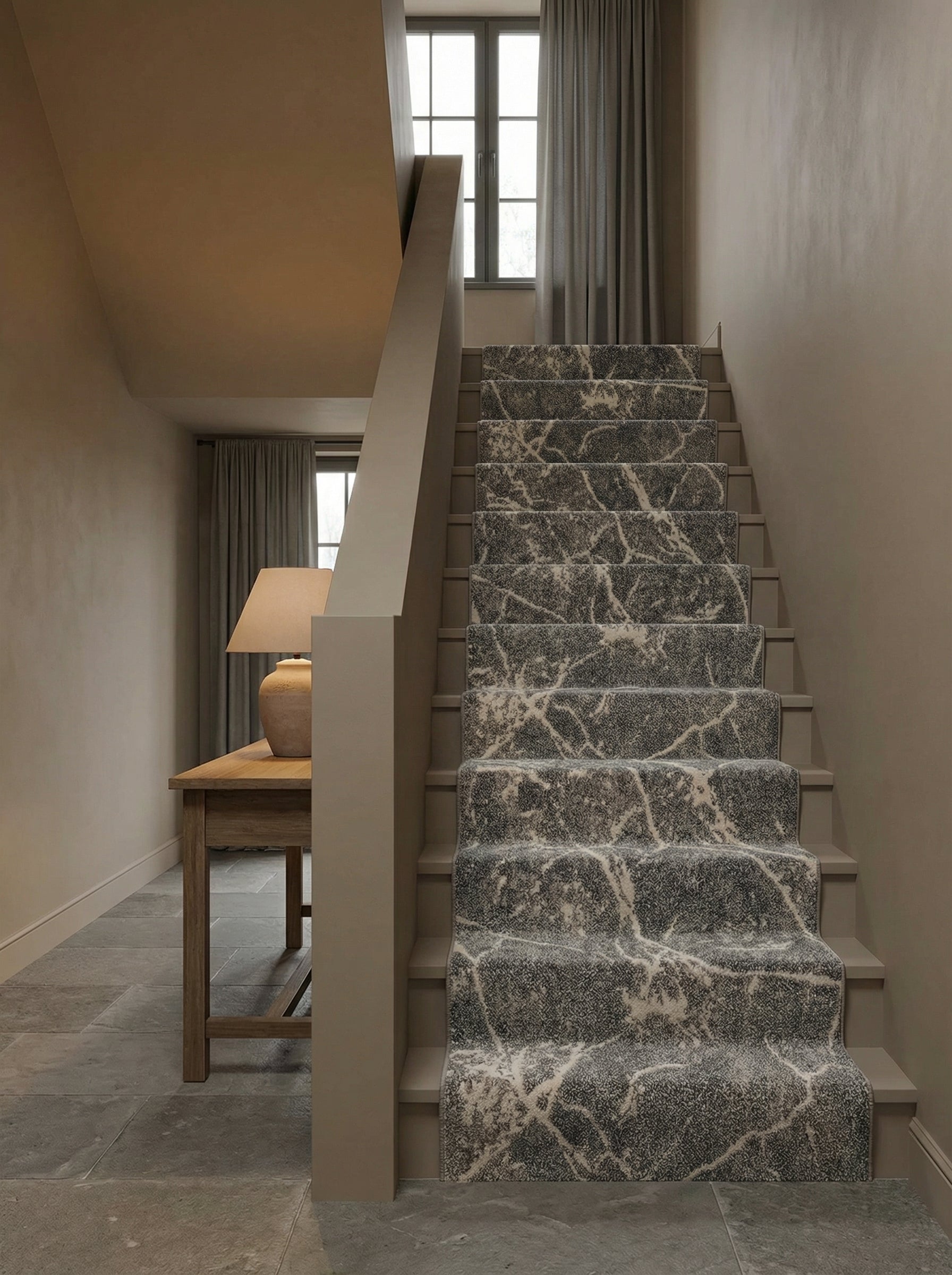 Tapis d'escalier gris foncé texturé avec des motifs irréguliers blancs simulant le marbre, installé dans un hall d'entrée