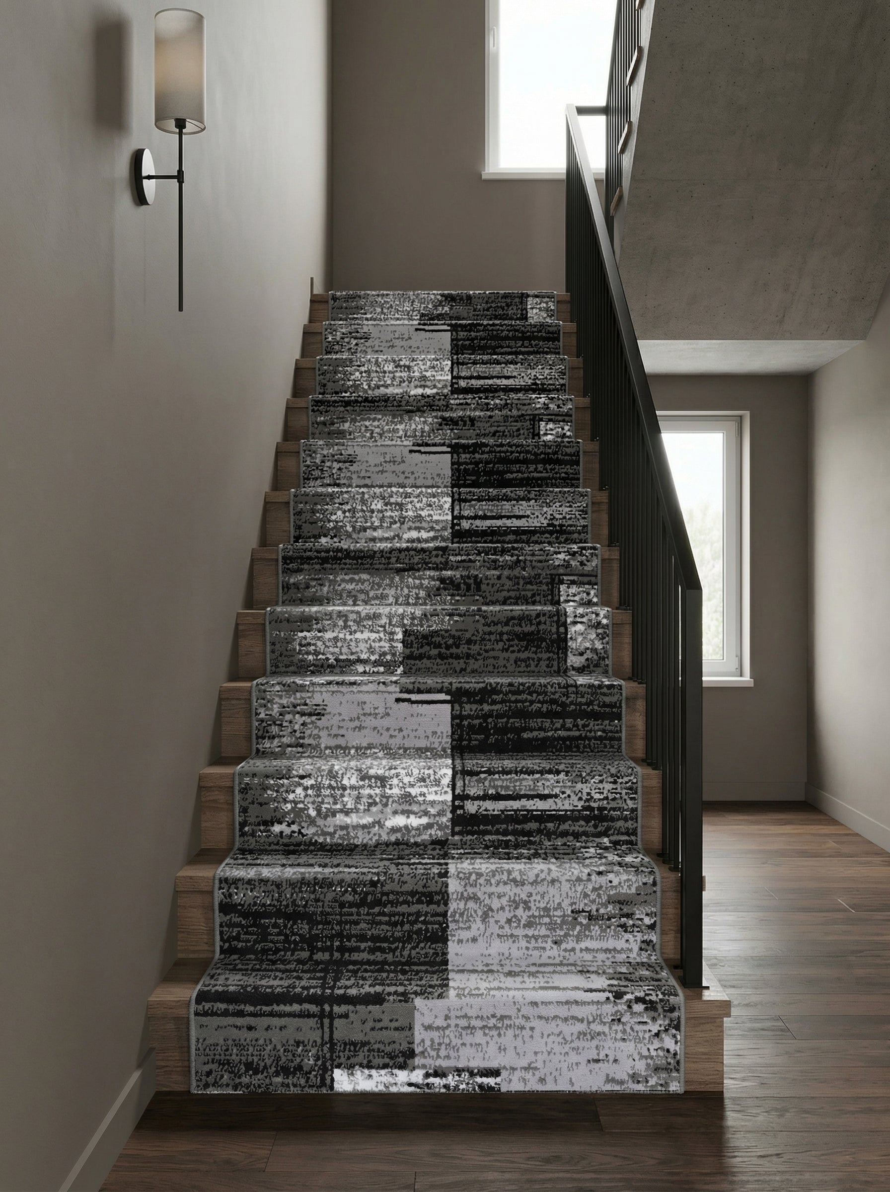 Tapis d'escalier en tissu aux motifs abstraits noirs, gris et blancs en blocs alternés, sur des marches en bois d'une entrée moderne