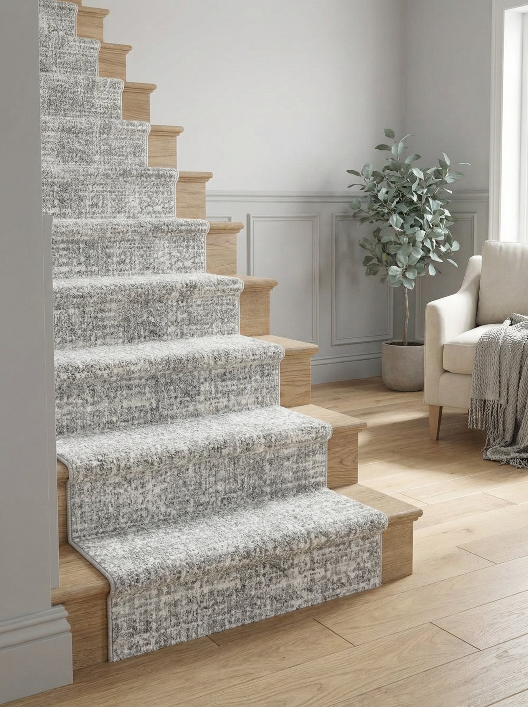 Tapis d'escalier texturé gris clair moucheté de blanc et gris foncé, recouvrant les marches en bois d'un salon lumineux