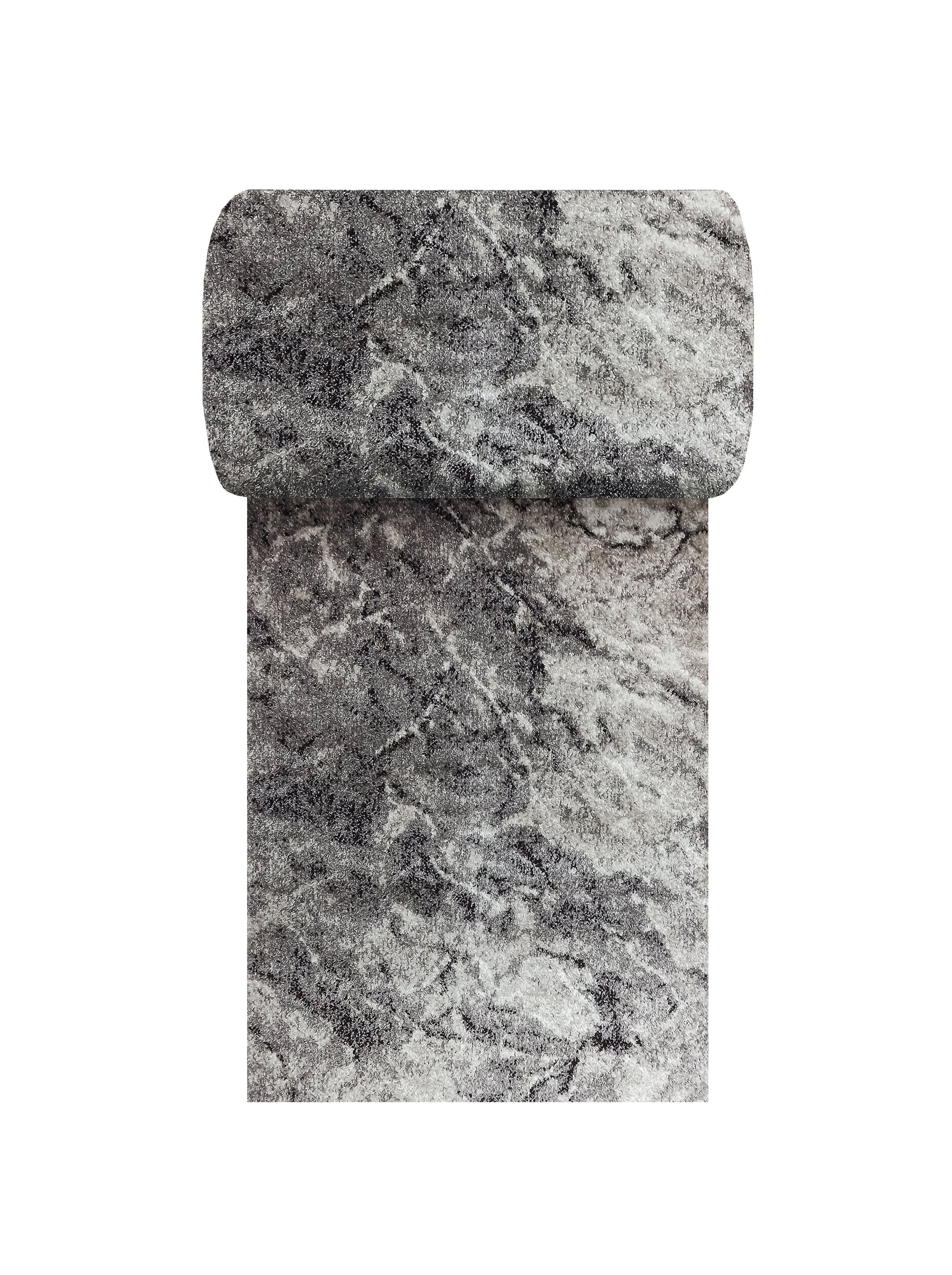 Tapis enroulé aux longs poils, avec un motif abstrait marbré dans des tons de gris clair et foncé