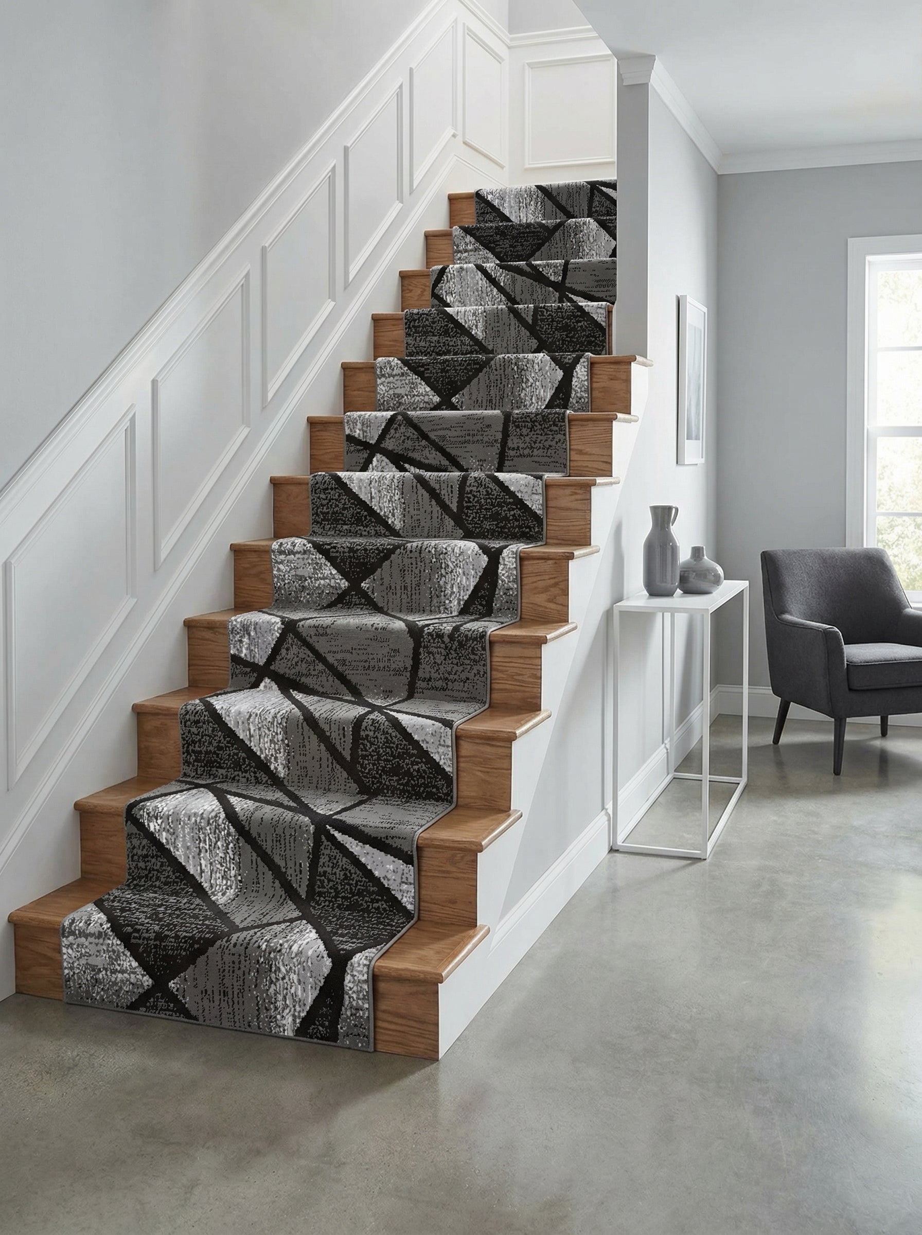 Tapis d'escalier gris et noir à motifs géométriques abstraits recouvrant des marches en bois clair dans une entrée moderne