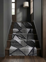 Tapis d'escalier gris, noir et blanc aux motifs géométriques abstraits texturés, sur des marches en bois foncé dans un hall