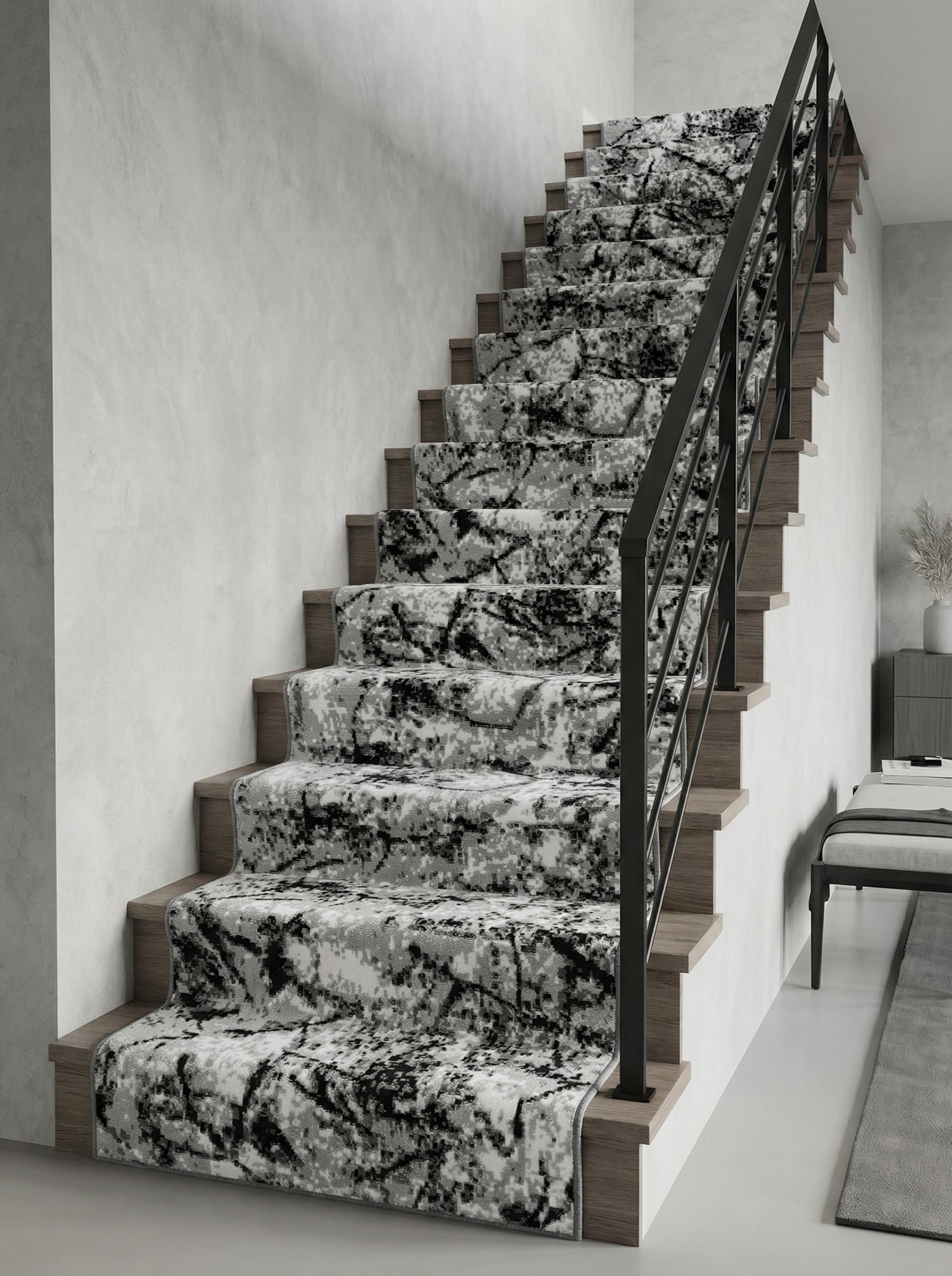 Tapis d'escalier gris, blanc et noir aux motifs abstraits et texturés, posé sur un escalier en bois clair dans un hall moderne