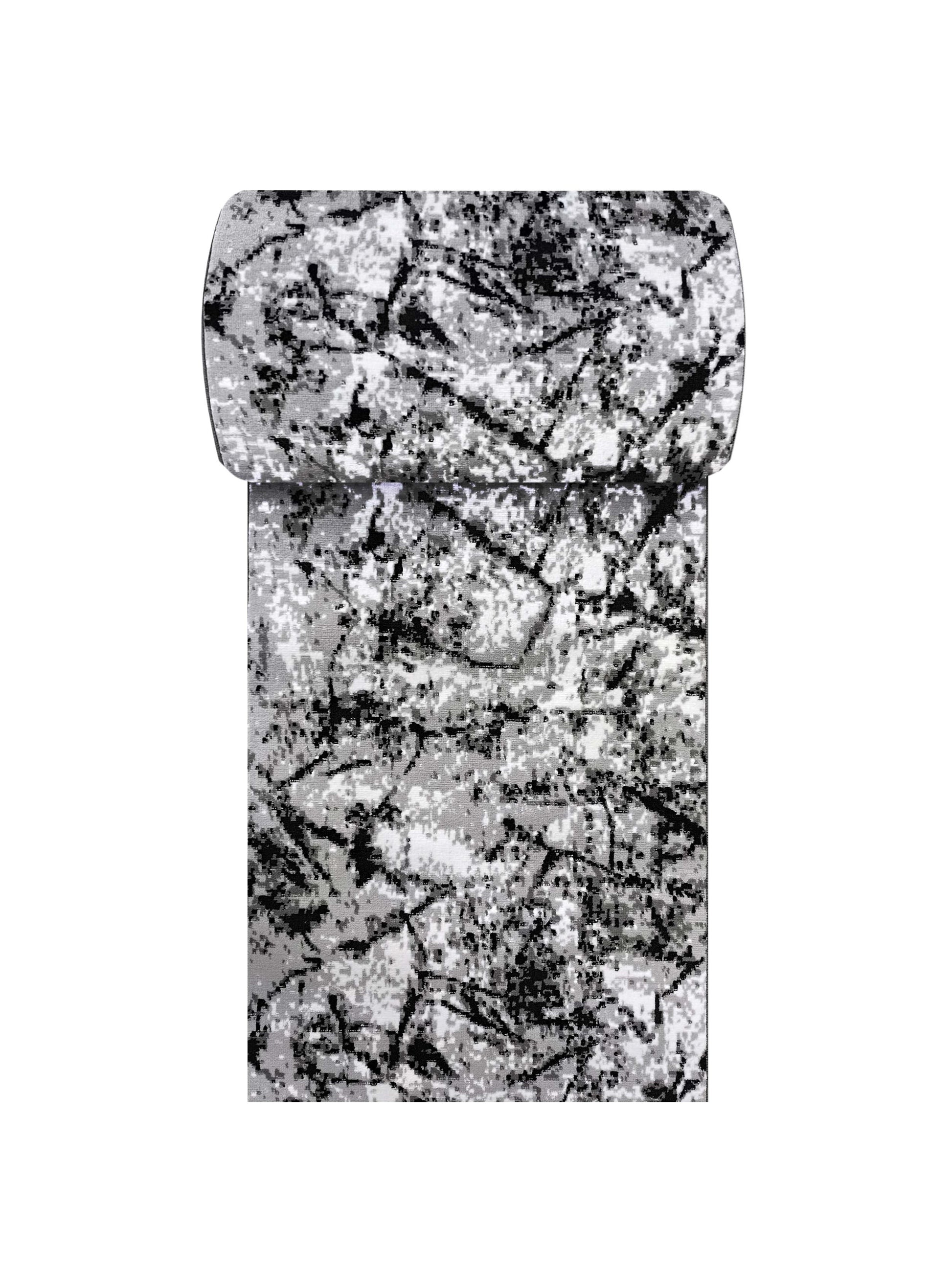 Tapis rectangulaire avec un motif abstrait de tons gris et noirs sur fond blanc, partiellement roulé