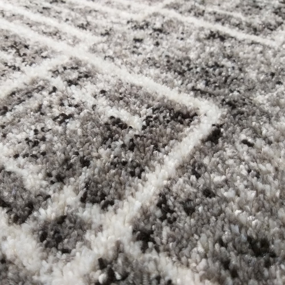 Un tapis à poils longs de couleur gris chiné avec des motifs géométriques abstraits blancs