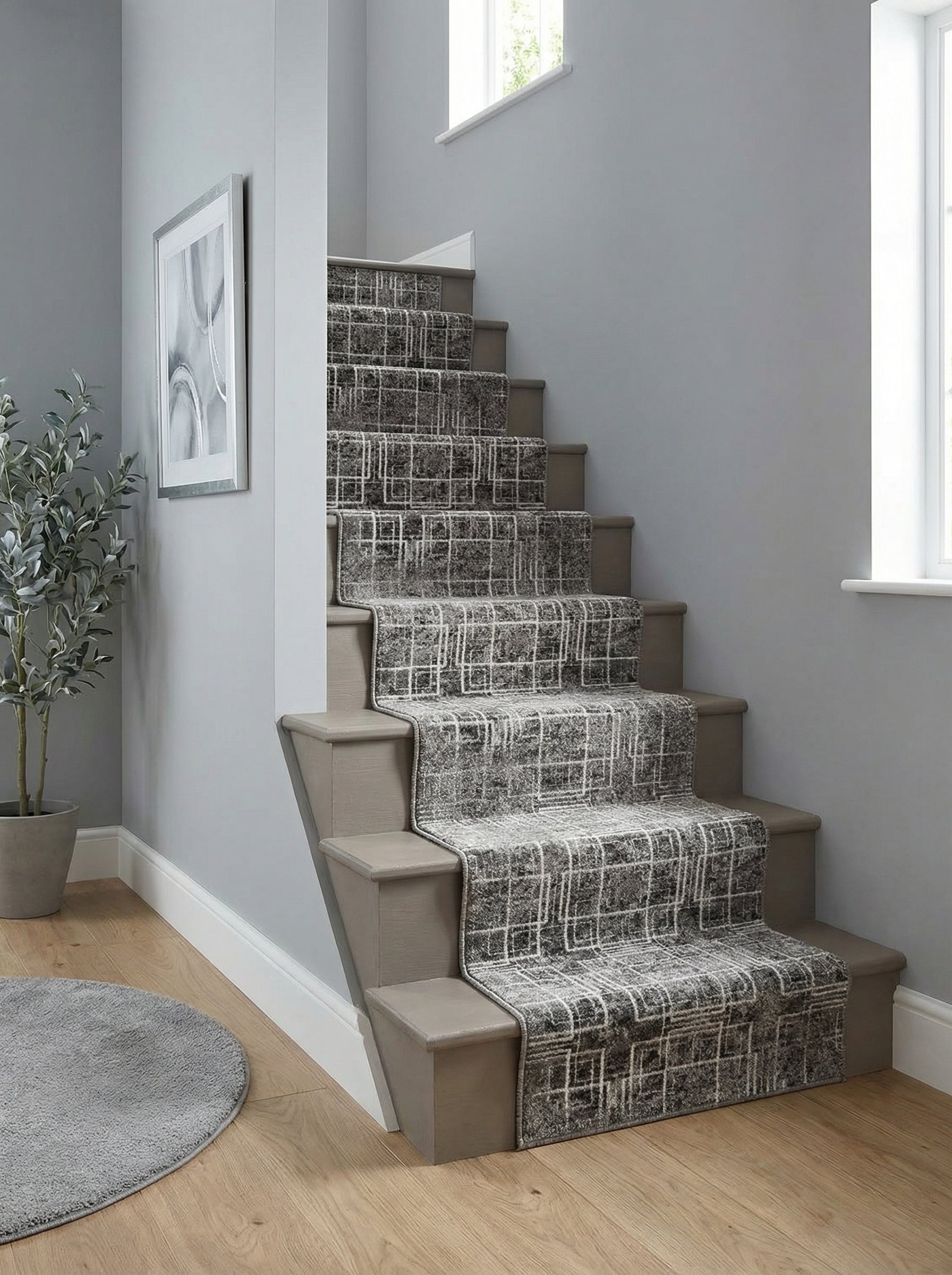 Tapis d'escalier gris foncé à motifs quadrillés abstraits blancs, s'étendant dans une entrée moderne