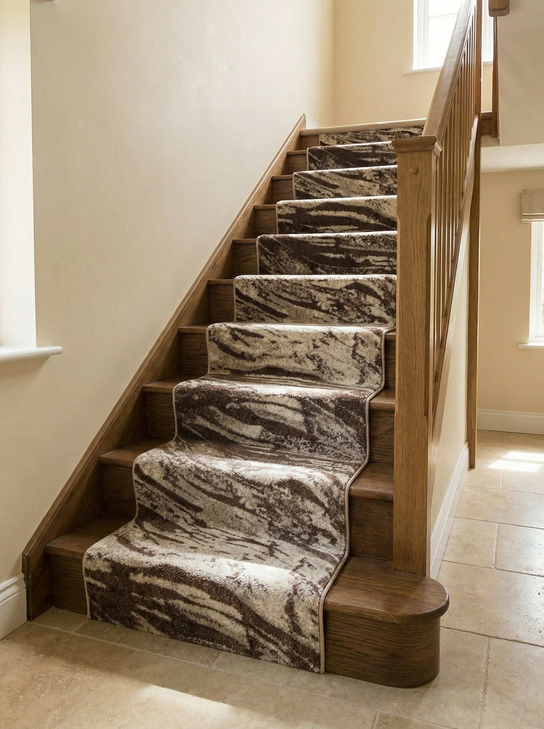 Tapis de couloir marron et beige à motifs abstraits recouvrant un escalier en bois clair dans une entrée