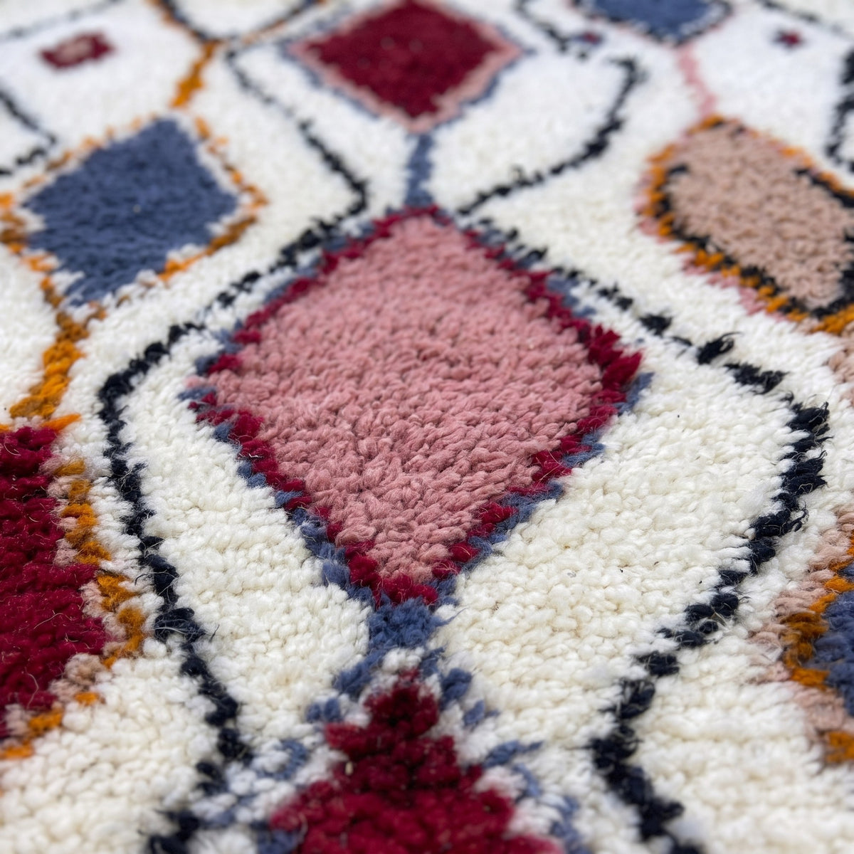 Gros plan sur un motif du tapis de couloir berbère Anaruz, couloir à poil long, fond écru, treillis noir