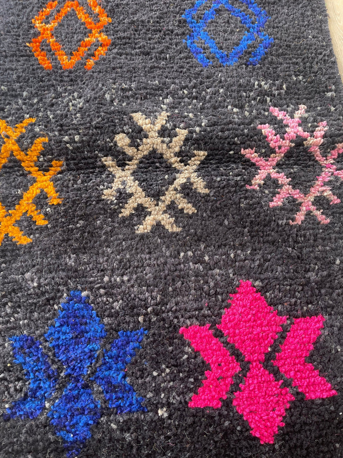 Gros plan sur la laine du tapis de couloir berbère Zemilt, poil noir multicolore noué à la main