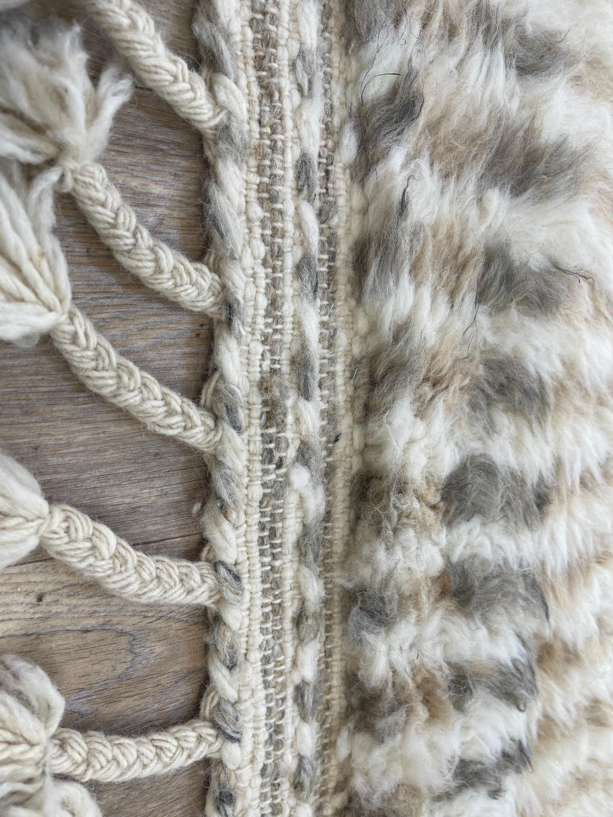 Gros plan sur les franges du tapis de couloir berbère Tamri, écrues tressées à pompons, nouées à la main