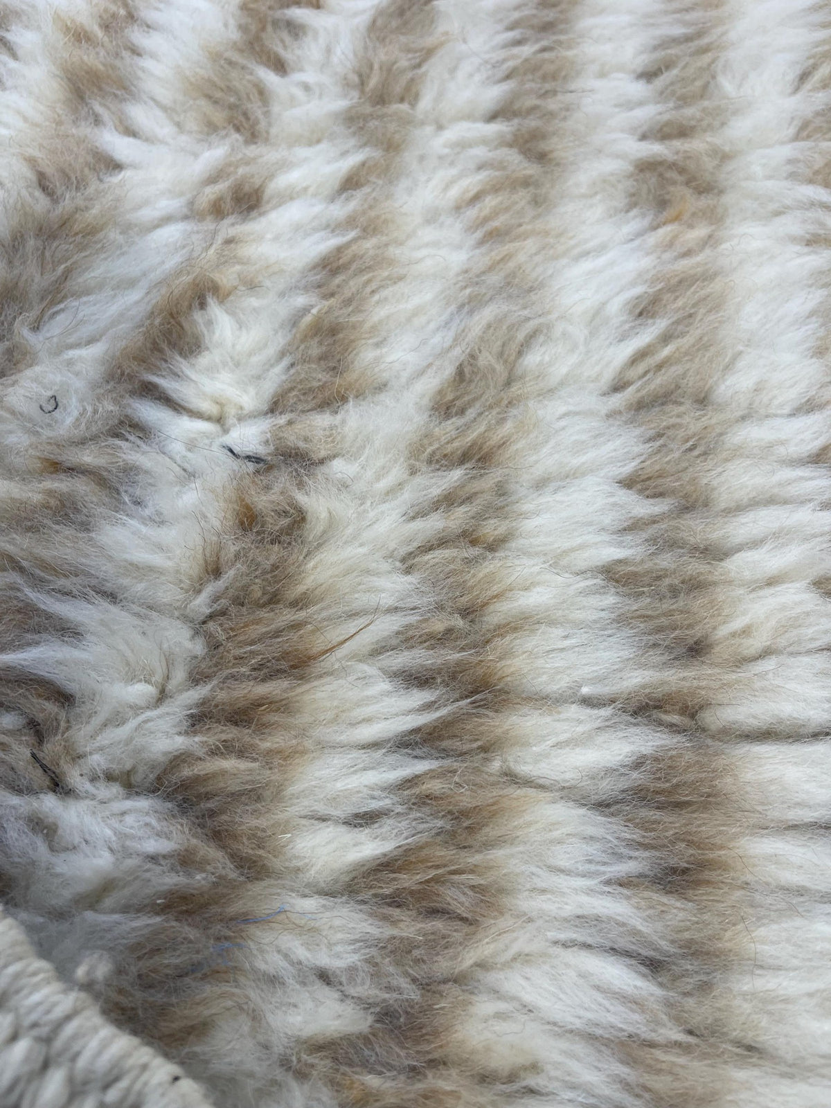 Gros plan sur la laine du tapis de couloir berbère Tamri, poil beige et blanc noué à la main