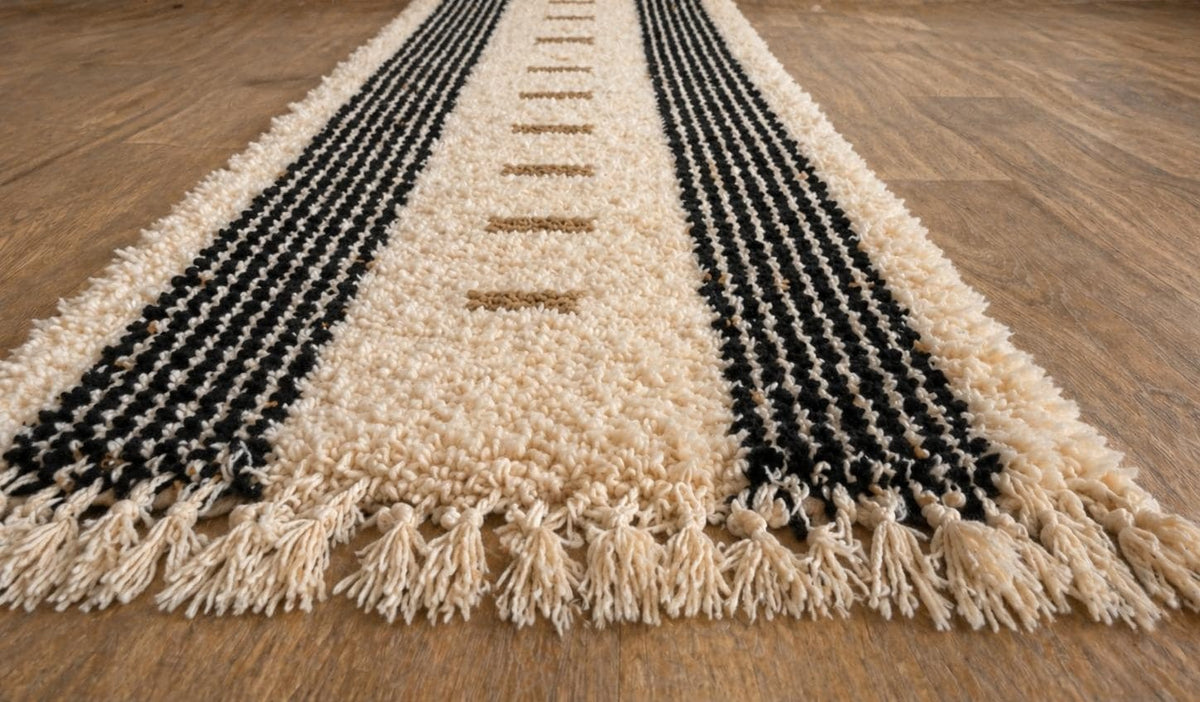 Tapis de couloir berbère à rayures blanc et noir Tallunt posé au sol vu de côté, noué main au Maroc