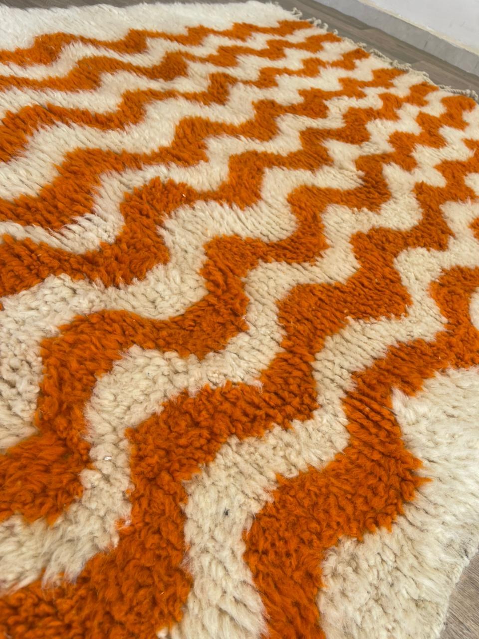 Gros plan sur la laine du tapis de couloir berbère Loumzal, laine de mouton au poil long, orange et blanche