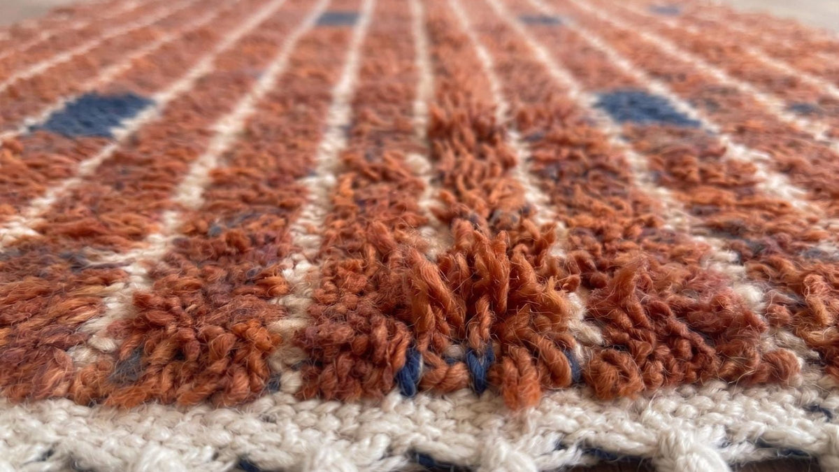 Gros plan sur la laine du tapis de couloir berbère Tichka, poil terracotta noué à la main
