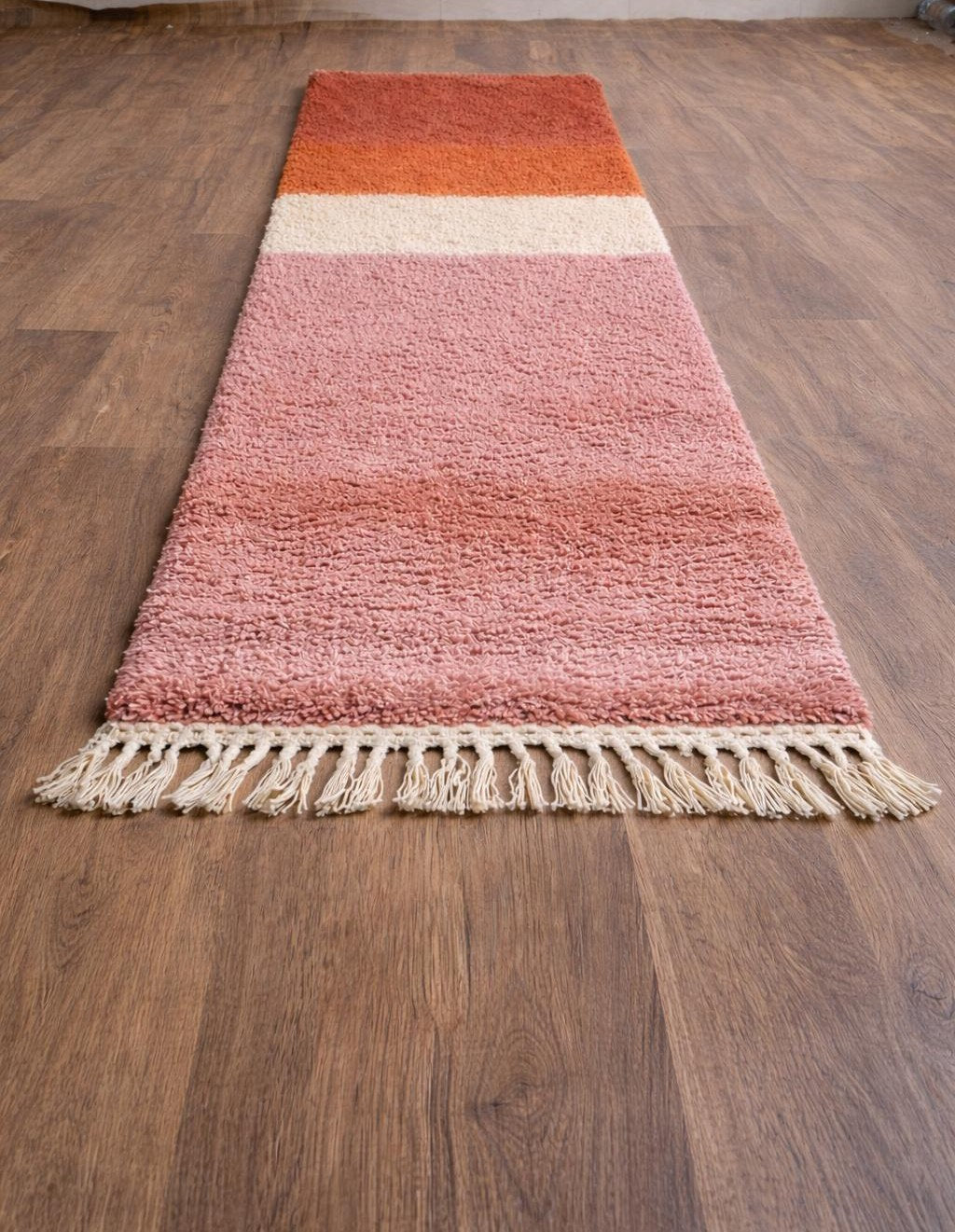Tapis de couloir berbère coloré rose et orange Mayyu posé au sol vu en biais, noué main au Maroc