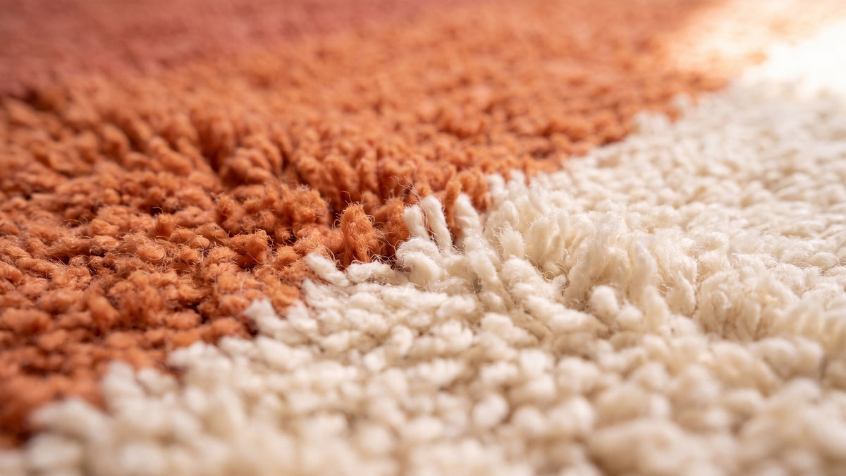 Gros plan sur la laine du tapis de couloir berbère Mayyu, poil rose et orange noué à la main