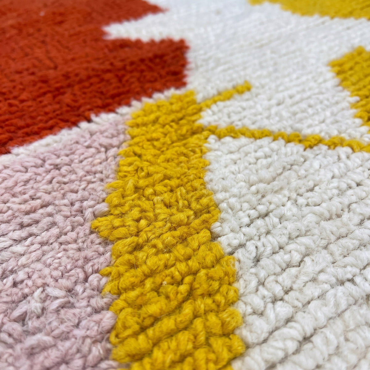 Gros plan sur un motif du tapis de couloir berbère Farsia, couloir écru à poil ras, motif en haut