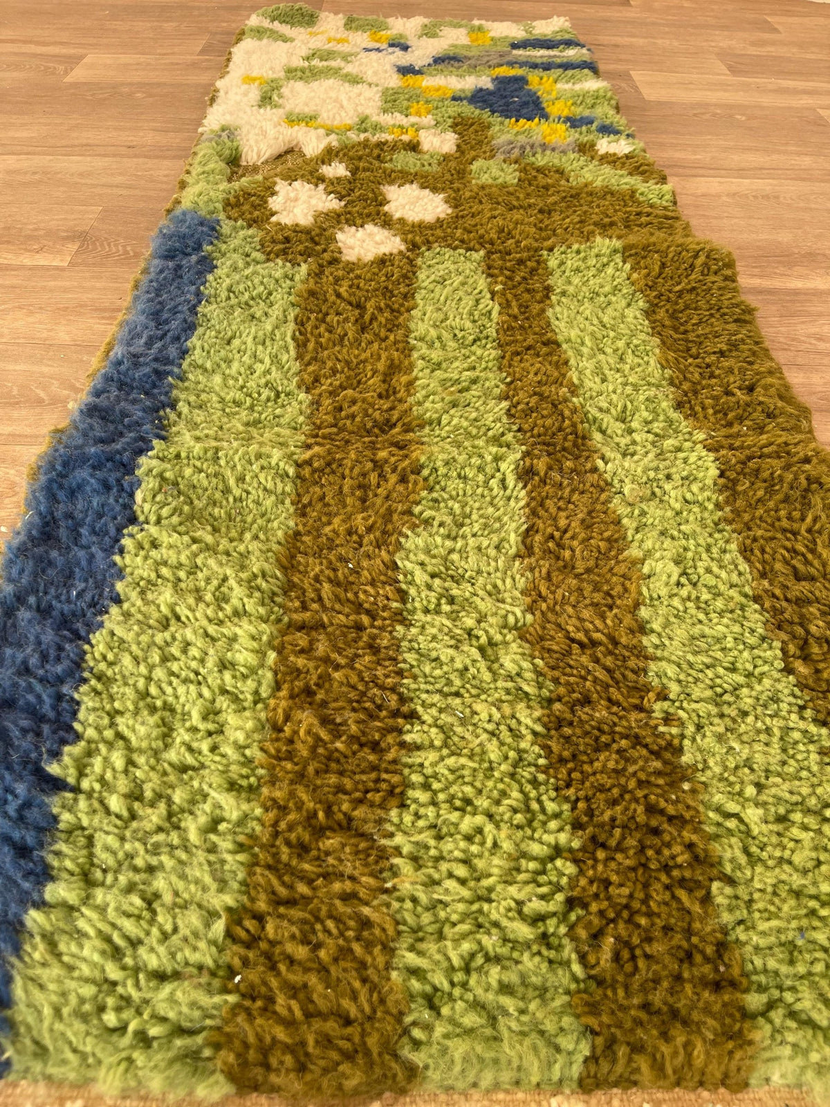 Tapis de couloir berbère coloré vert olive Berzoun posé au sol vu de côté, noué main au Maroc