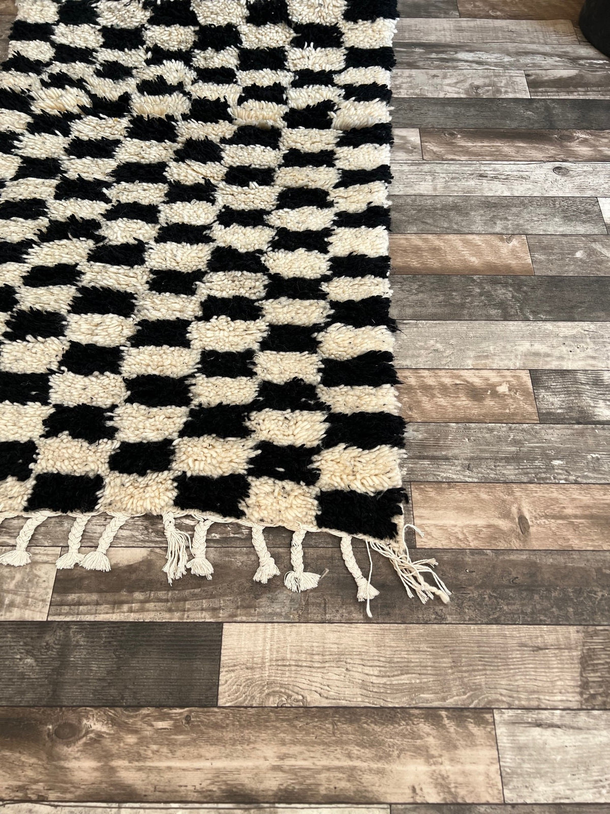 Gros plan sur les franges du tapis de couloir berbère Lemzoun, écrues torsadées et nouées, nouées à la main