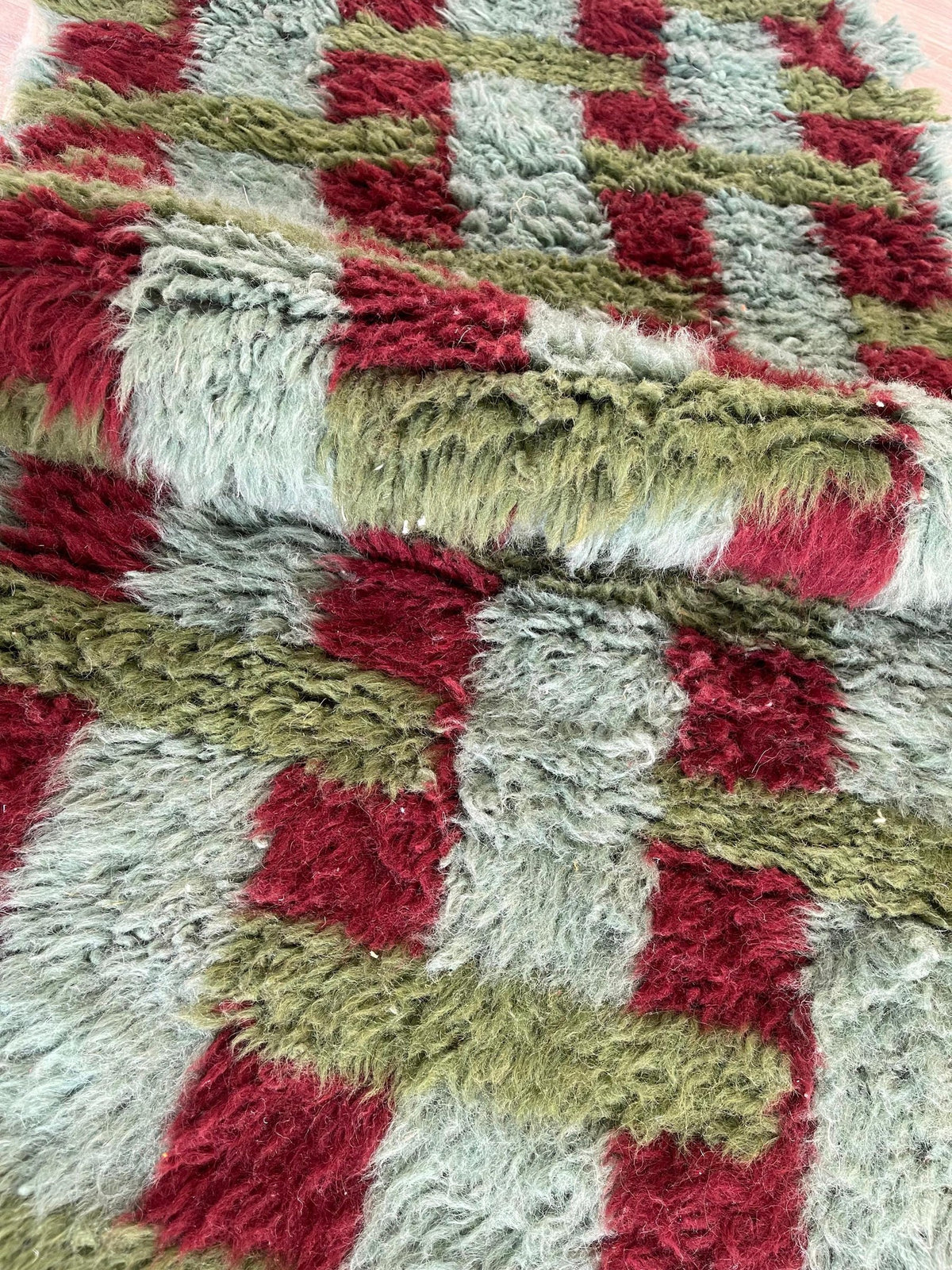 Gros plan sur la laine du tapis de couloir berbère Oualidia, poil vert et bordeaux noué à la main