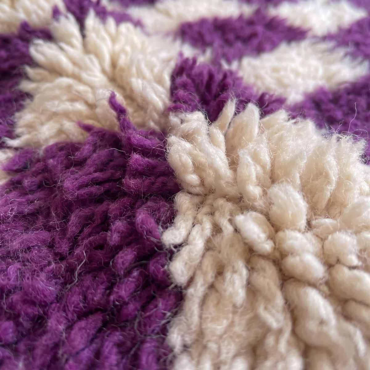 Gros plan sur un motif du tapis de couloir berbère Zerrouka, couloir poil long et dense, damier régulier violet