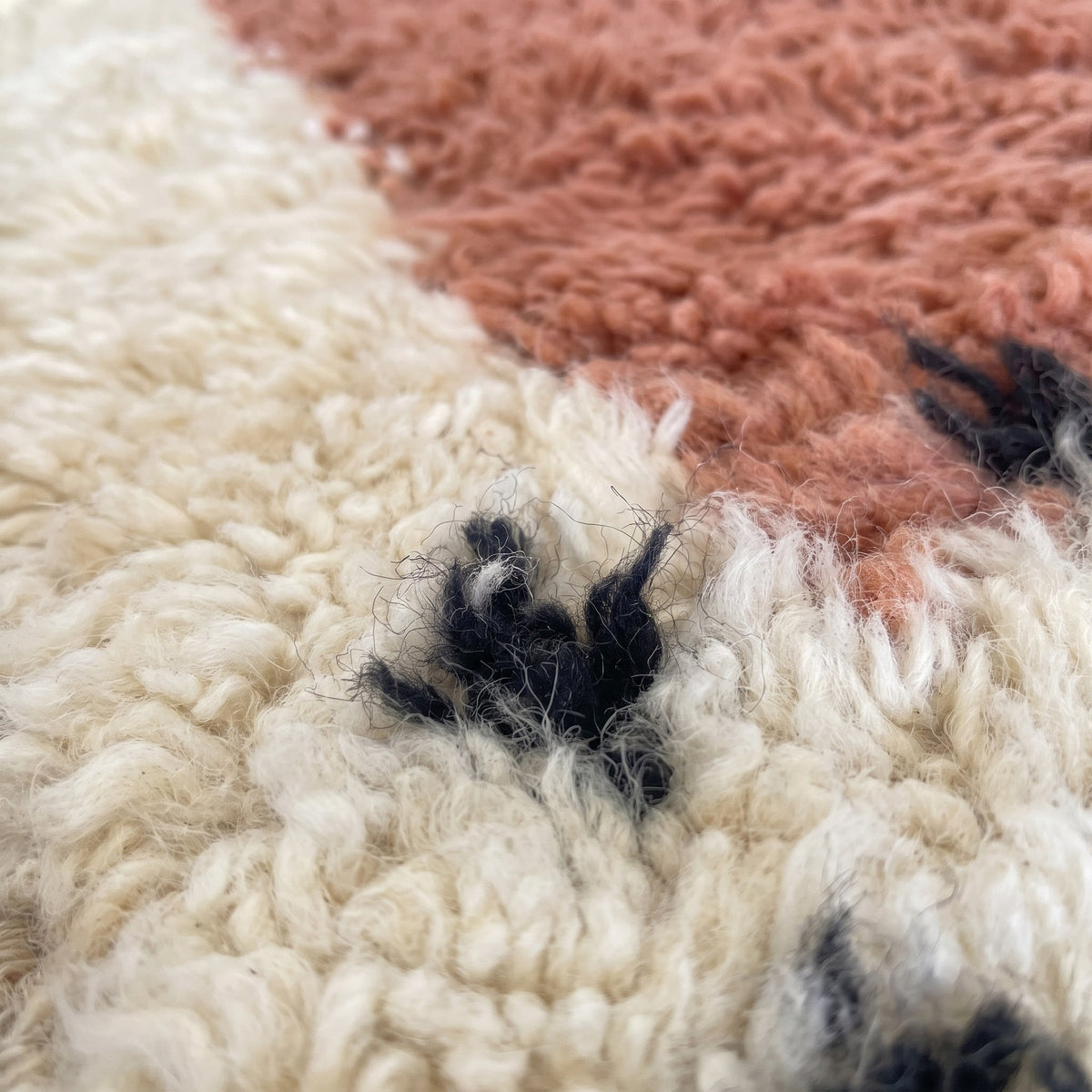 Gros plan sur un motif du tapis de couloir berbère Adissa, couloir écru à poil long, rectangle terre cuite
