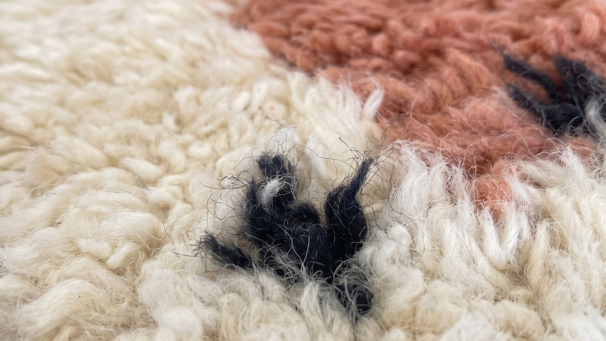 Gros plan sur la laine du tapis de couloir berbère Adissa, poil blanc et terracotta noué à la main