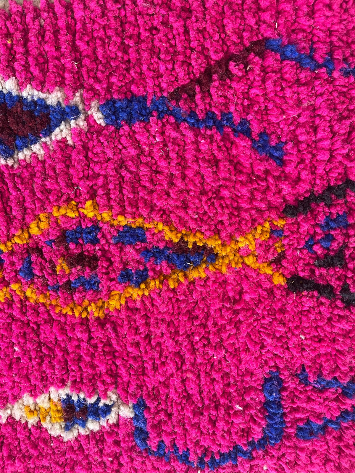 Gros plan sur la laine du tapis de couloir berbère Asayis, laine de mouton au poil moyen, fuchsia multicolore