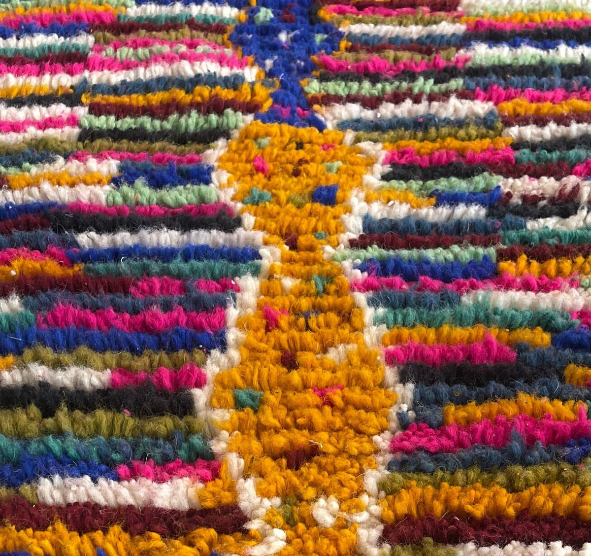 Gros plan sur la laine du tapis de couloir berbère Asayis, nœuds serrés et tracé du motif de près