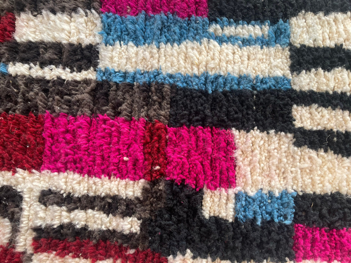 Gros plan sur la laine du tapis de couloir berbère Belrouan, laine de mouton au poil long, multicolore