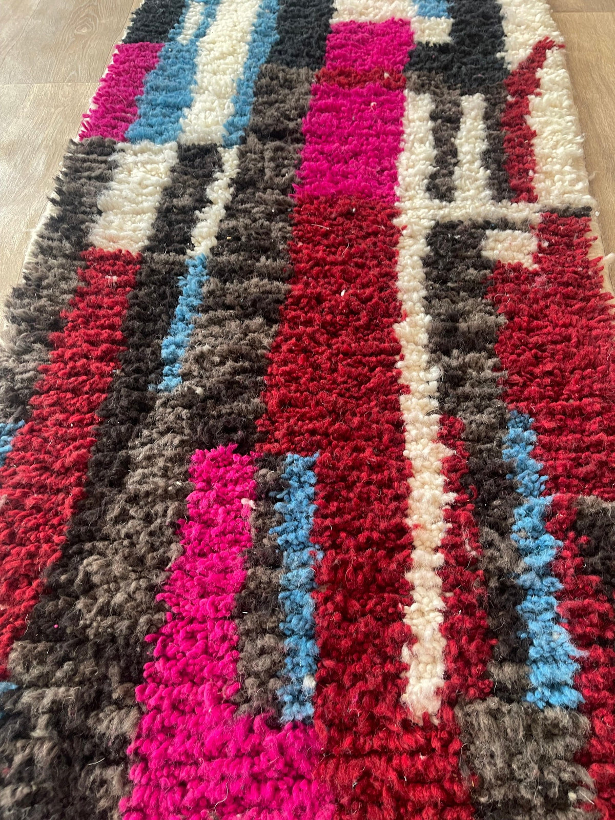 Gros plan sur un détail du tapis de couloir berbère Belrouan, poil long et motif multicolore vus de près