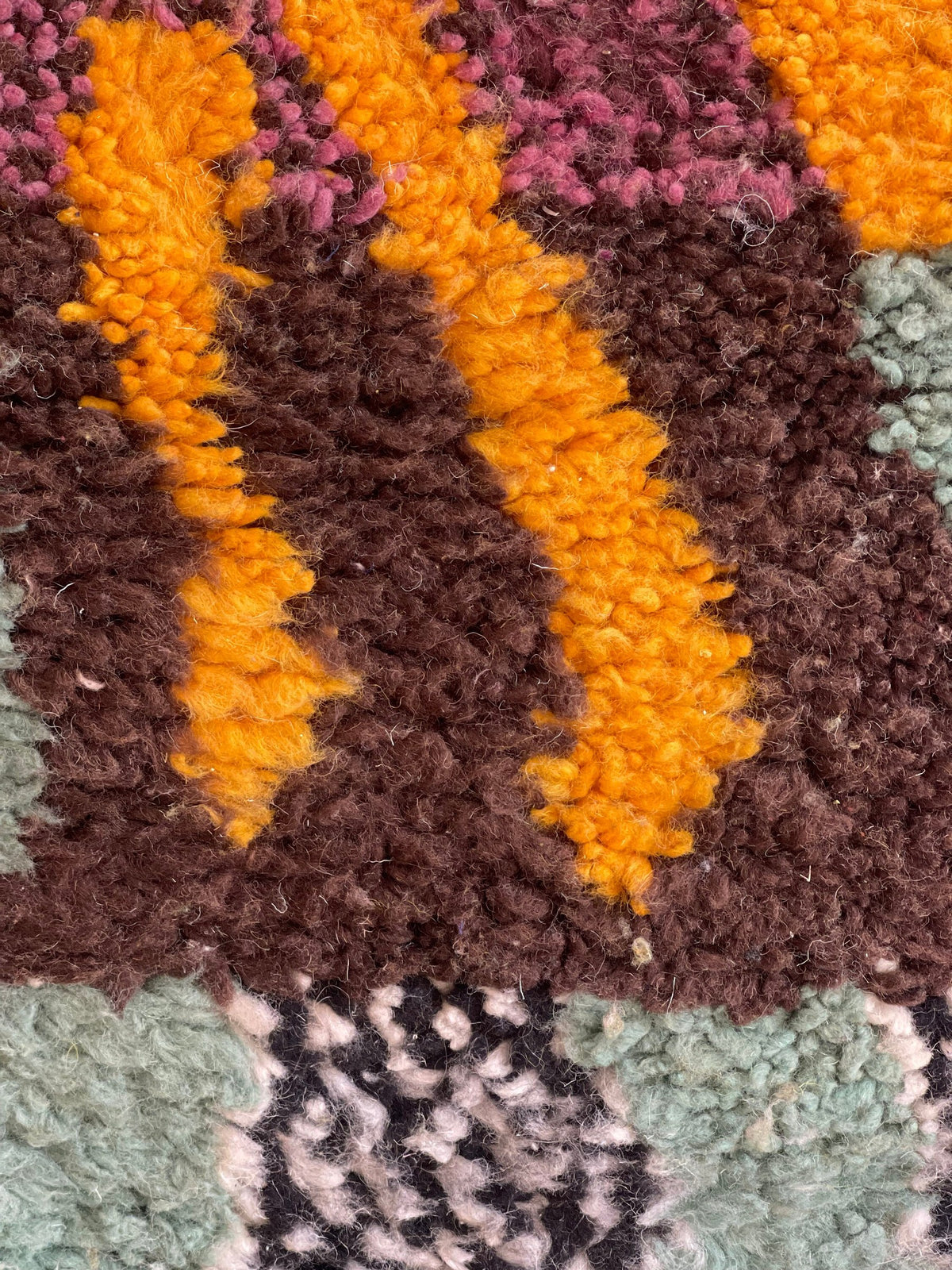 Gros plan sur la laine du tapis de couloir berbère Kerdous, laine de mouton au poil long, multicolore