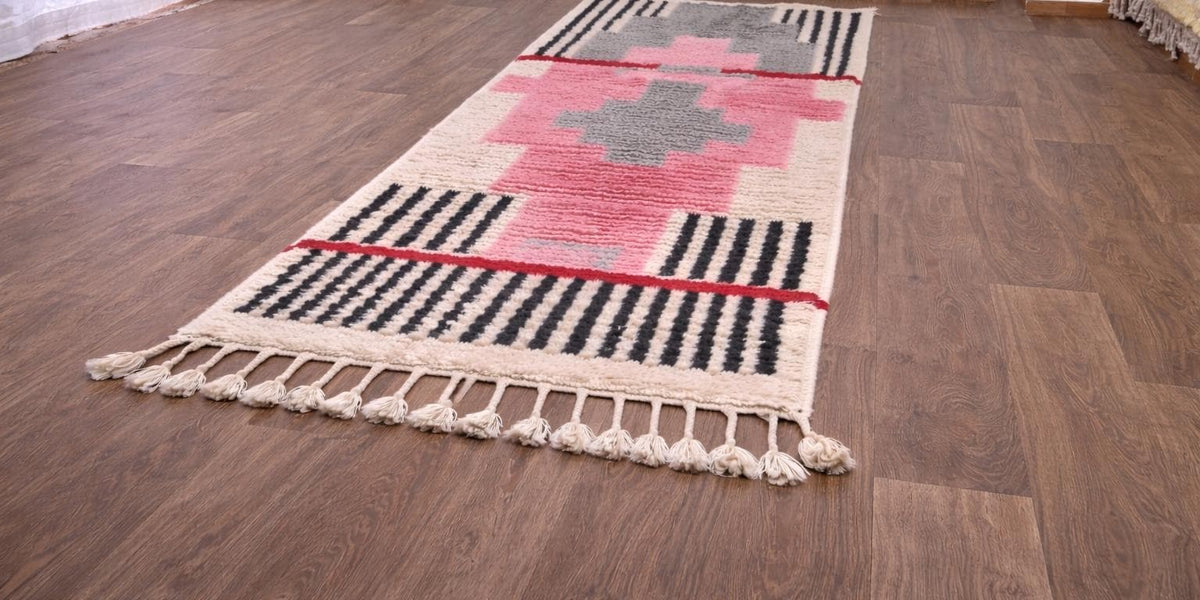 Timzila graphic Berber runner in pink and grey, on the floor, seen from the side at an angle, hand-knotted in Morocco