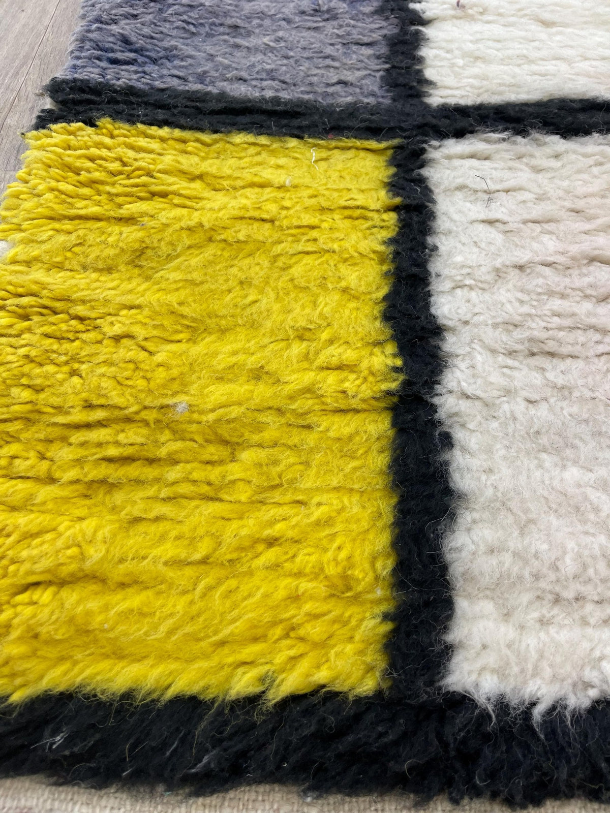 Gros plan sur la laine du tapis de couloir berbère Azetta, nœuds serrés et tracé du motif de près