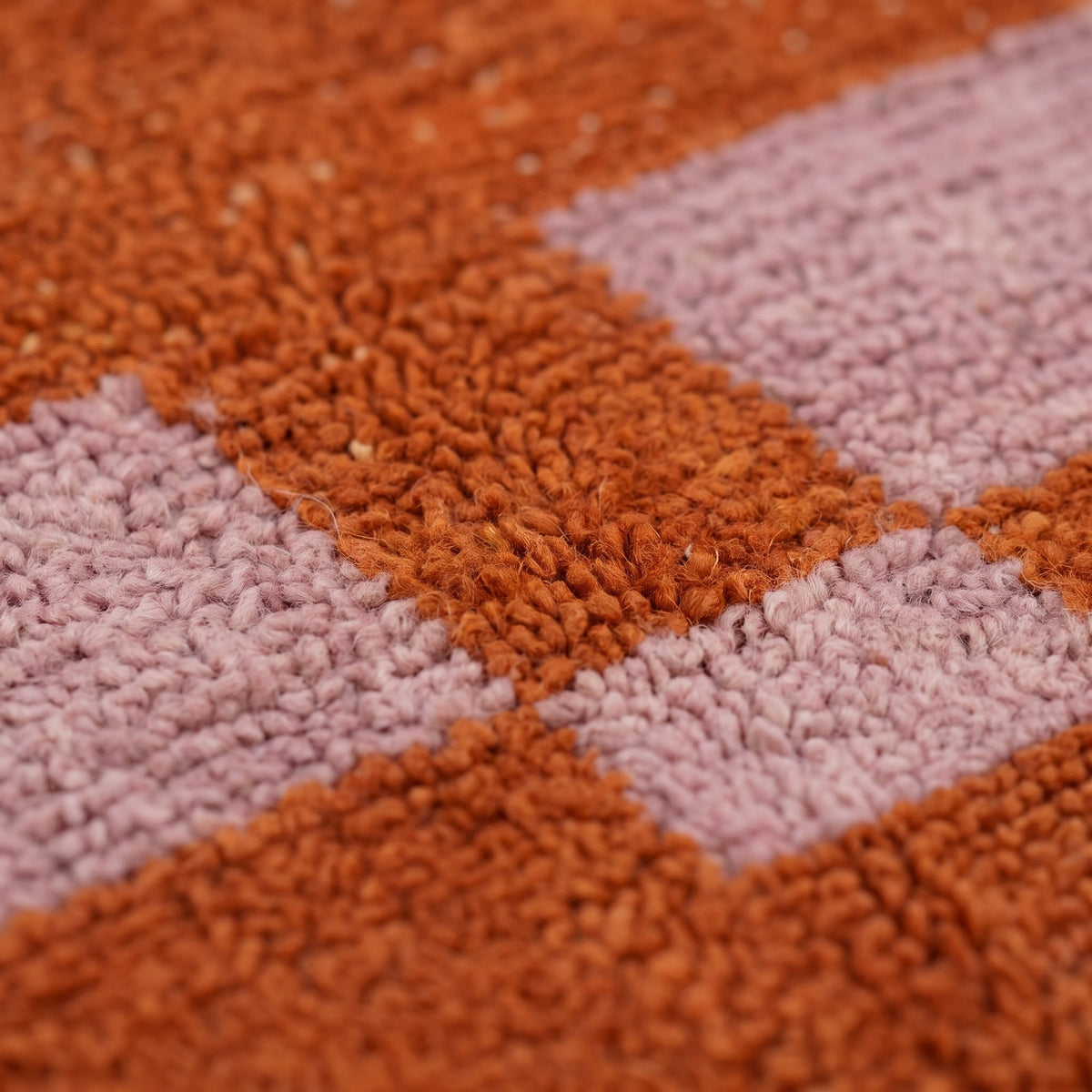 Gros plan sur un motif du tapis de couloir berbère Boumalne, couloir terracotta uni, deux rectangles rose poudré