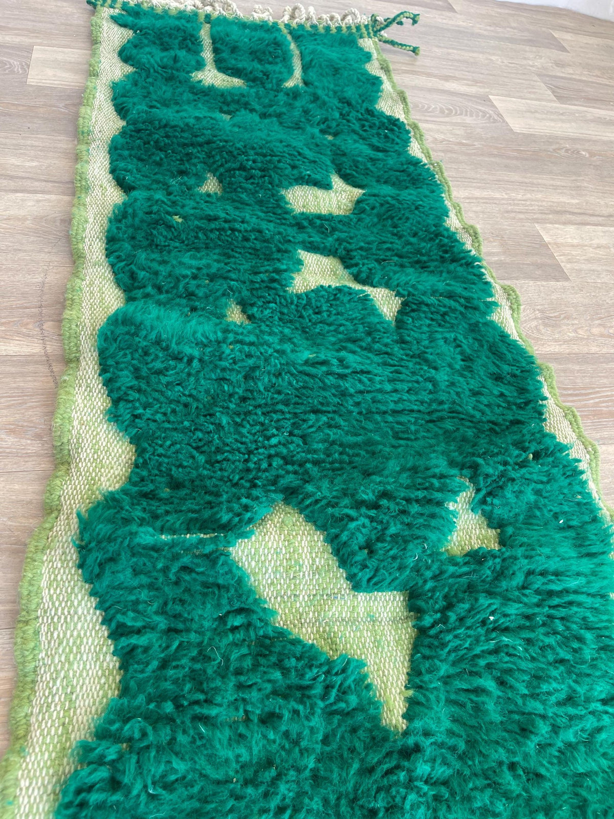 Gros plan sur un détail du tapis de couloir berbère Balissa, poil long et motif vert émeraude vus de près, vue 4
