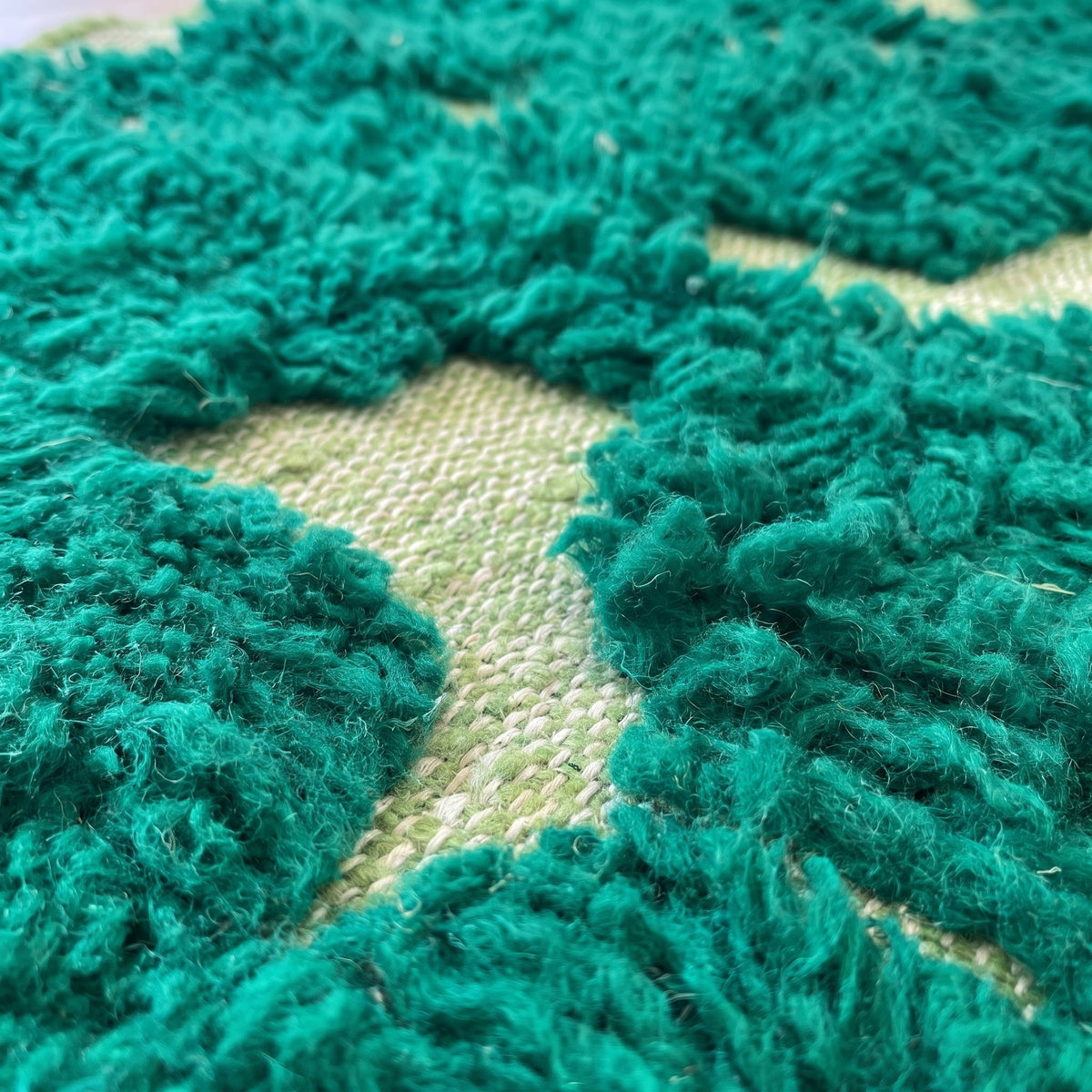 Gros plan sur un motif du tapis de couloir berbère Balissa, couloir vert émeraude à poil long découpé