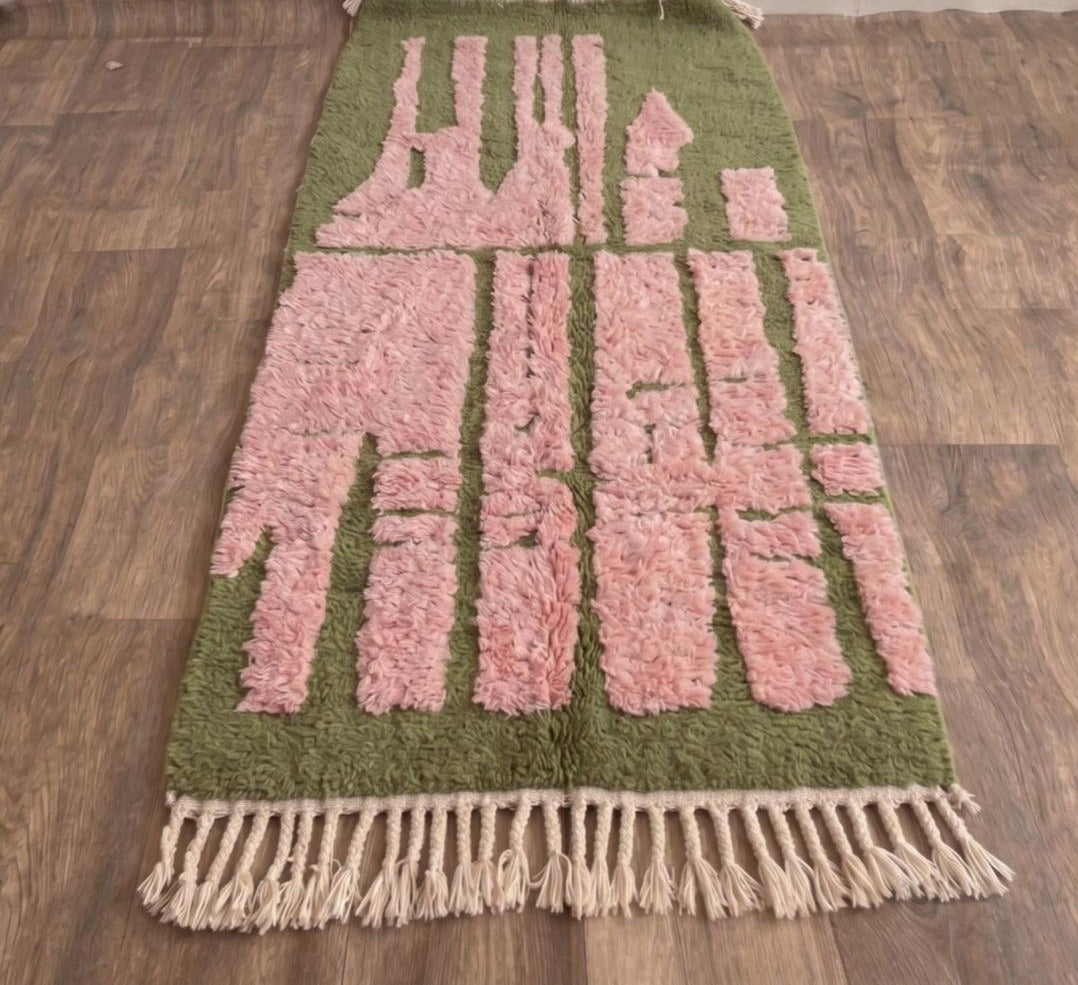 Tapis de couloir berbère graphique vert et rose Figuig posé au sol vu de côté, noué main au Maroc