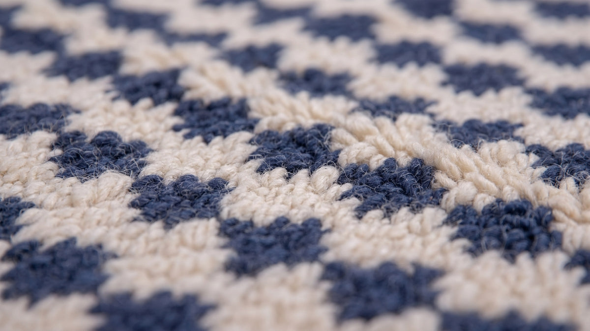 Gros plan sur la laine du tapis de couloir berbère Tamsoult, poil blanc et bleu noué à la main