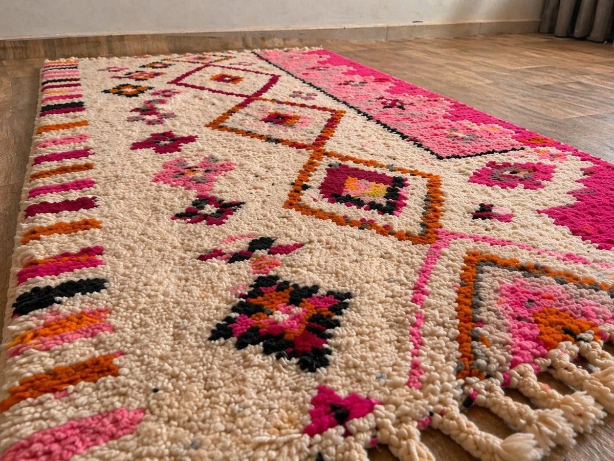 Gros plan sur la laine du tapis de couloir berbère Amrawen, laine de mouton au poil moyen, blanche et rose