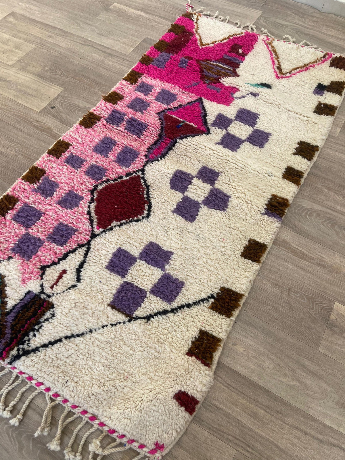 Tapis de couloir berbère style Azilal blanc et rose Zoumi posé au sol vu en biais, noué main au Maroc