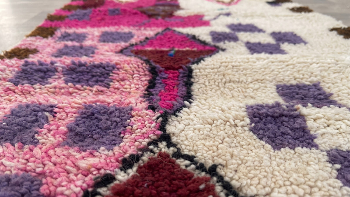 Gros plan sur la laine du tapis de couloir berbère Zoumi, poil blanc et rose noué à la main