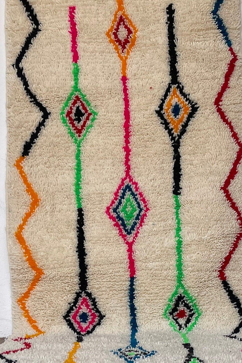 Gros plan sur la laine du tapis de couloir berbère Rafdil, laine de mouton au poil long, blanc multicolore