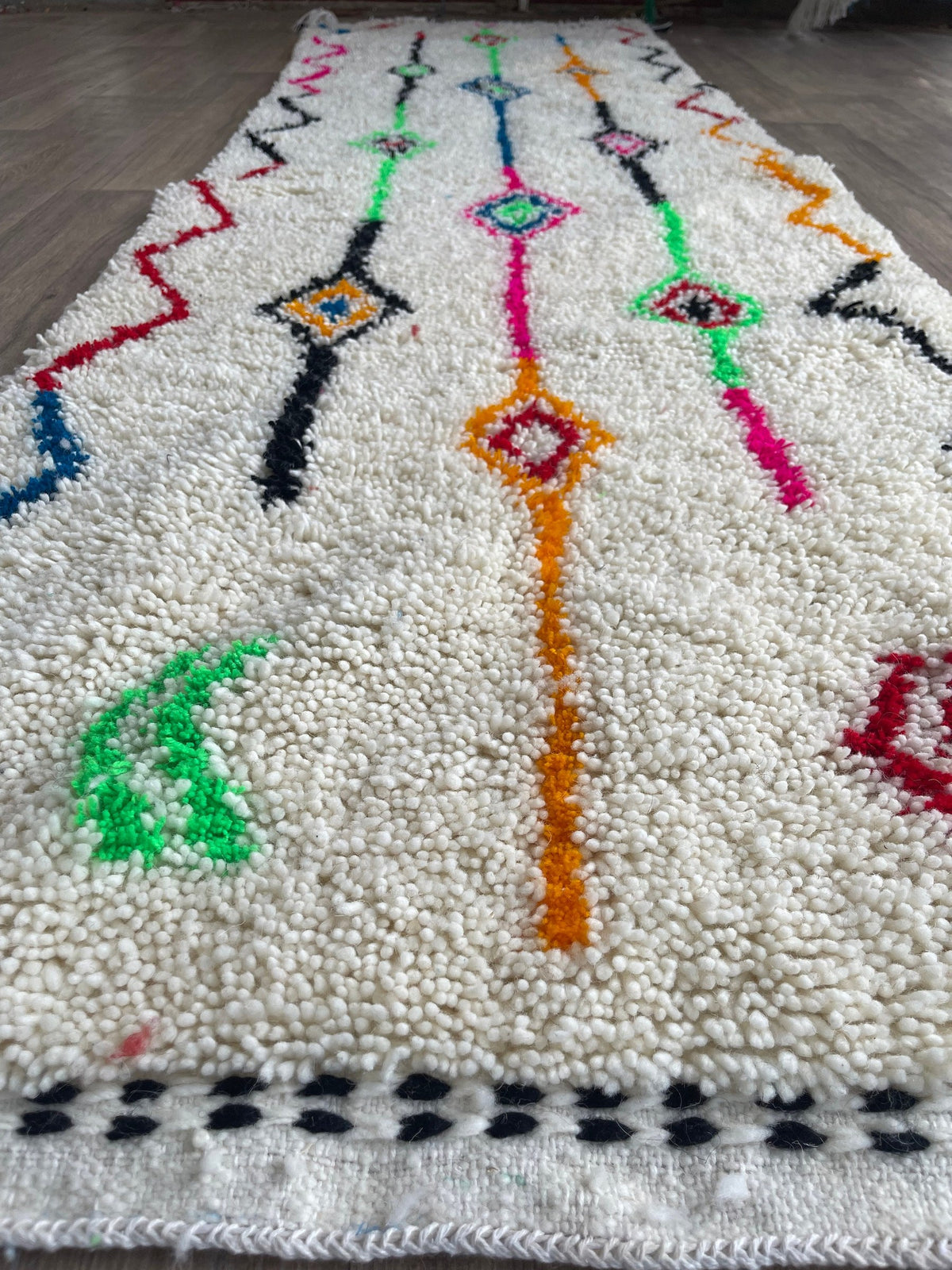 Gros plan sur la laine du tapis de couloir berbère Rafdil, texture de la laine naturelle et nuances du poil